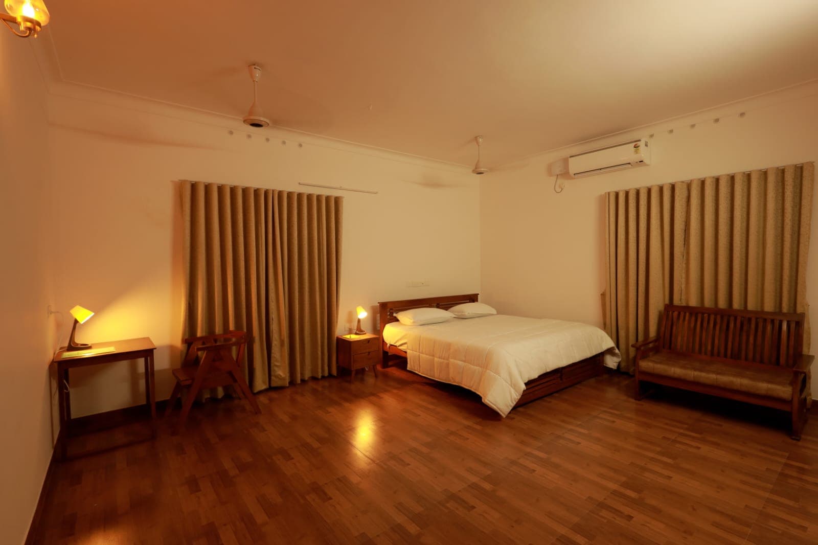 King bedroom with timber floor and bench
