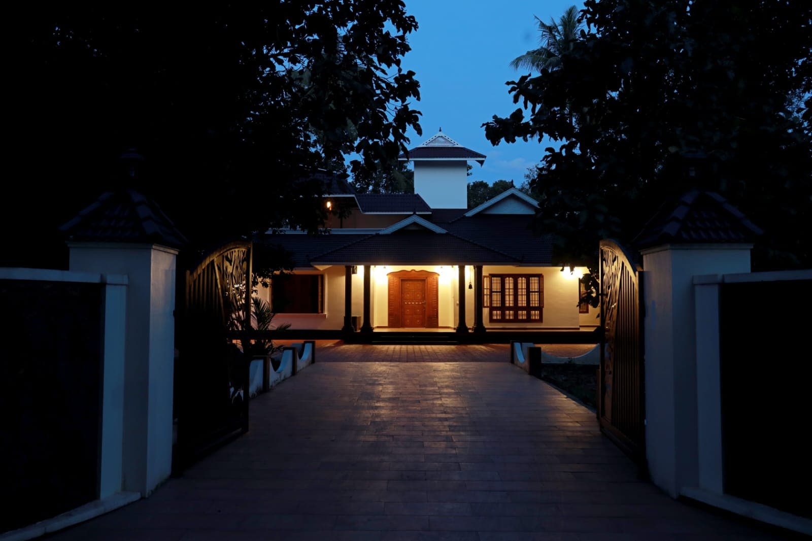 The lit portico of the house at blue hour